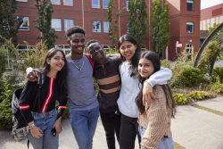 Photo of a diverse group of students standing outdoors on campus
