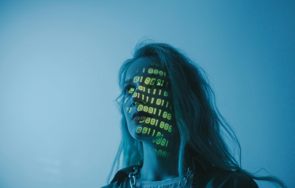 photo of a woman with binary code projected onto her face