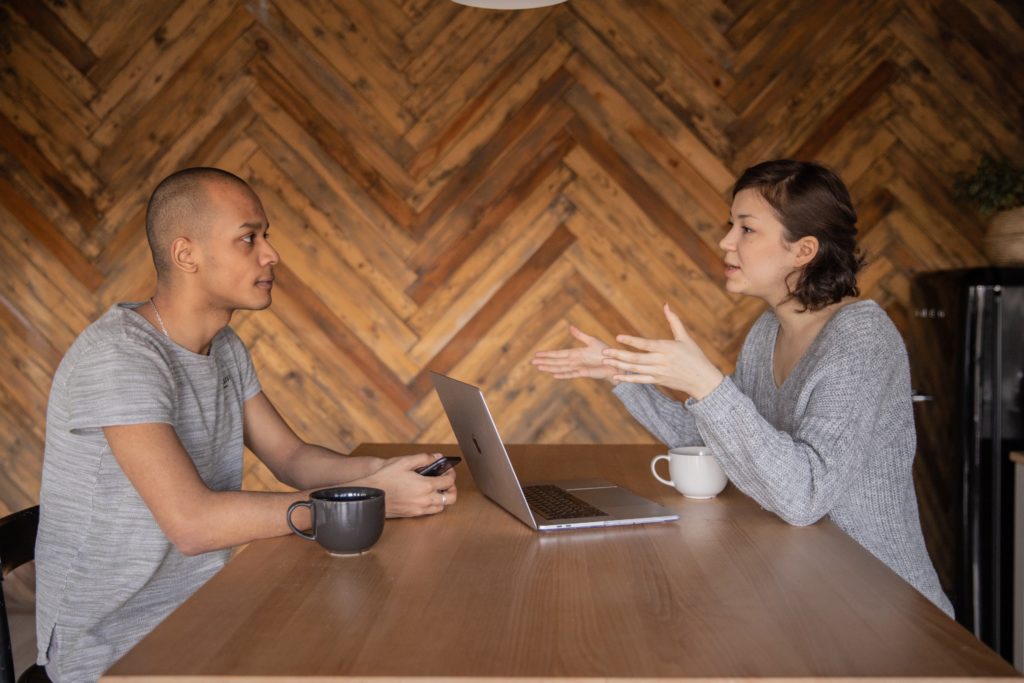 two students talking, sitting at the table