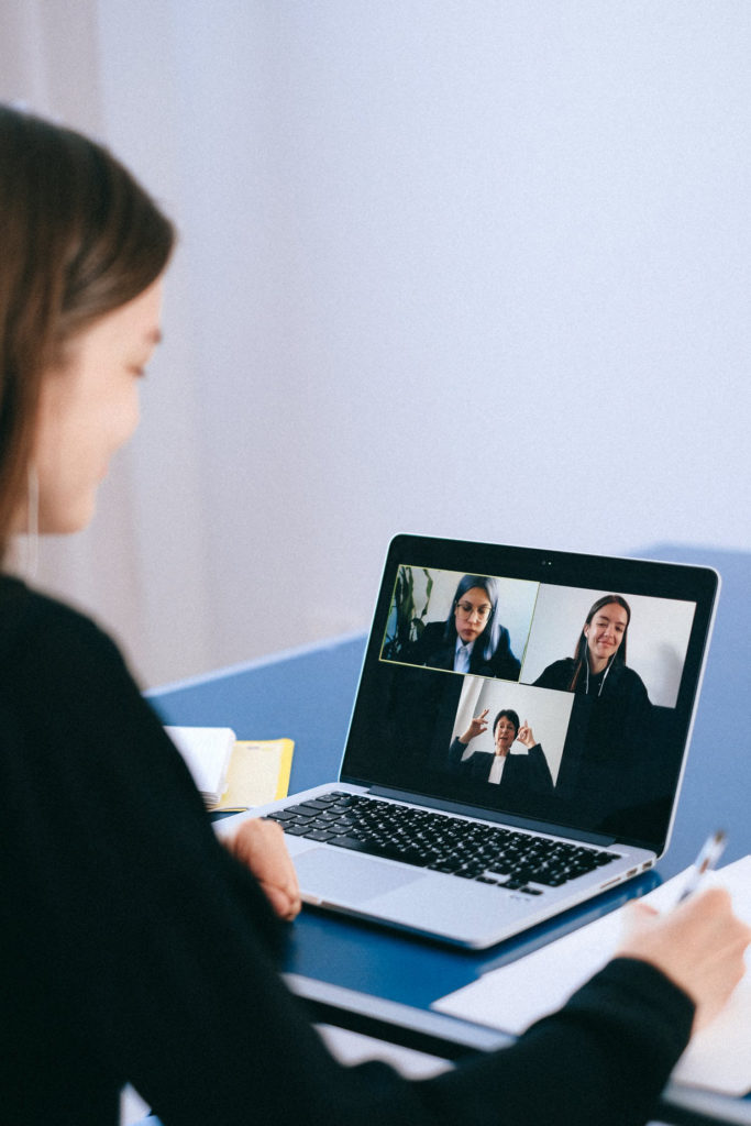 photo of a woman participating in a video call on a laptop computer