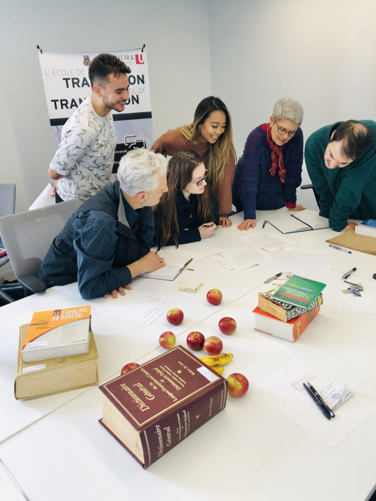 photo of a group of people around a table examining printed materials