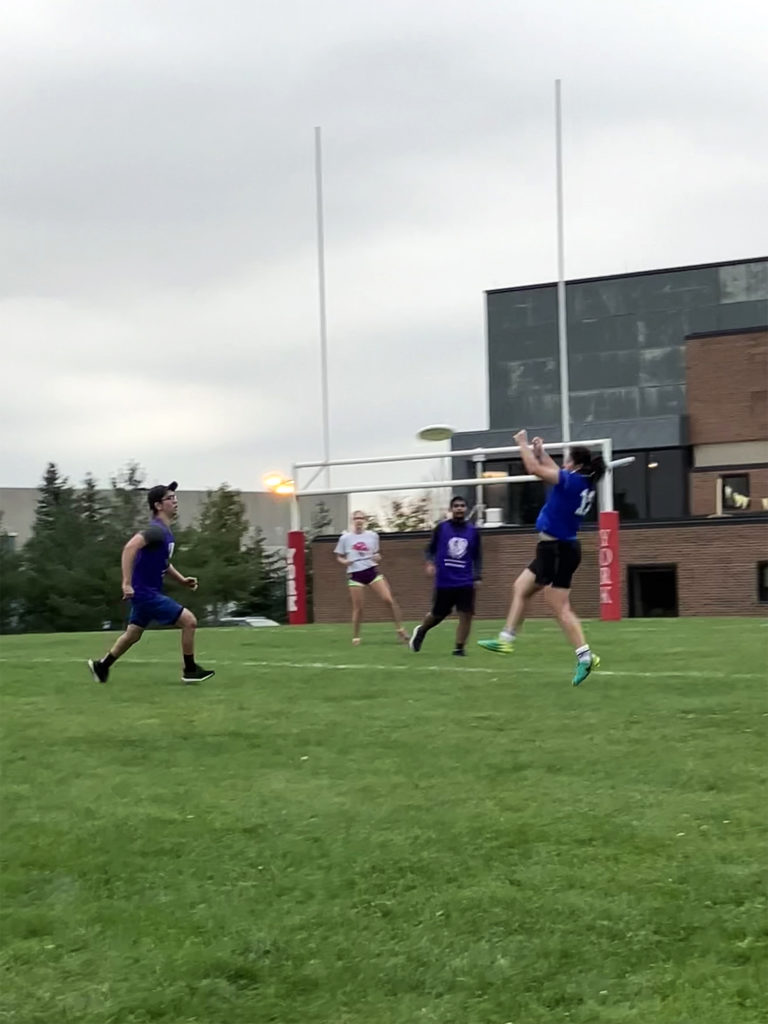 photo of a group of people playing frisbee on an outdoor field