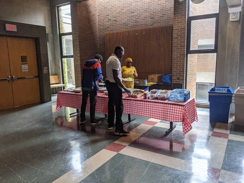 a couple of people getting food from the food table