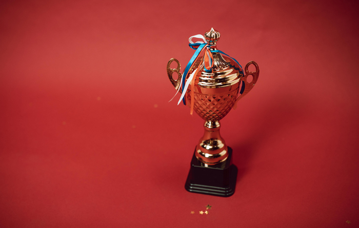 gold trophy with a black base on a red background