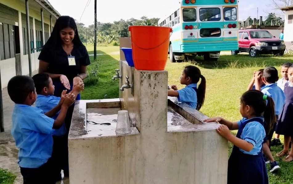 A student teaches kids washing hands