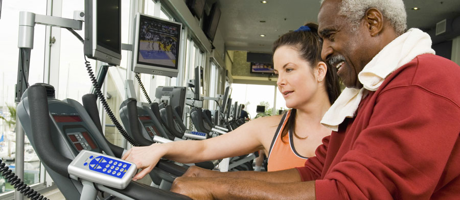 Trainer with a senior client on a treadmill