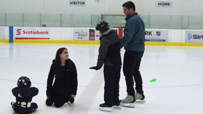 Kinesiology students helping children learn to skate.
