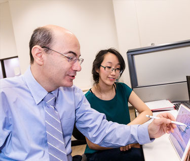 Professor and student working on an iPad