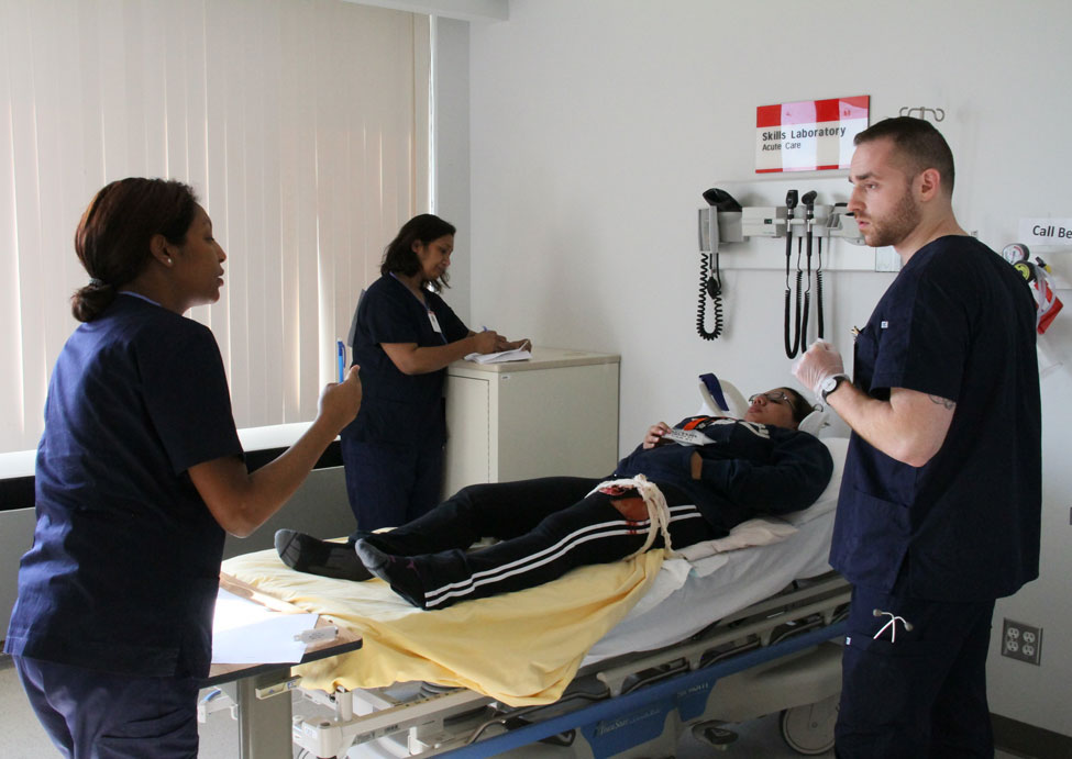Nursing students and professors assessing a patient in a simulated patient scenario