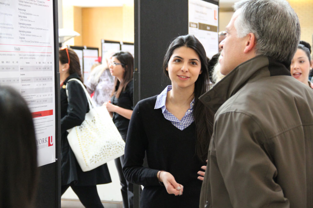 Psychology student presenting a poster of her research