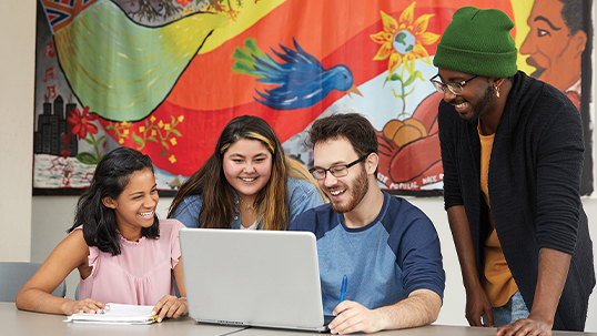 four students around laptop