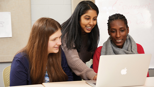 three women looking at laptop