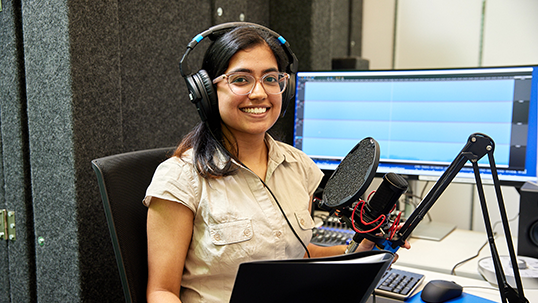 female student in front of microphone for radio show