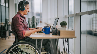 disable male sitting in wheelchair and working on a laptop