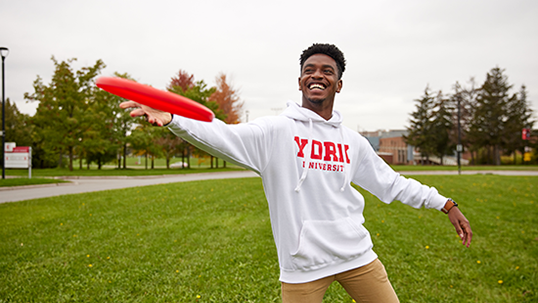 male student playing with Frisbee