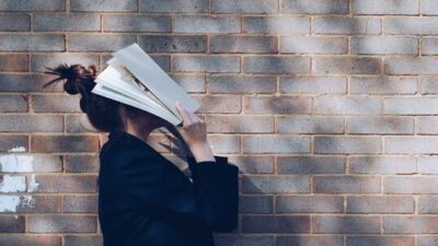 women with book on her face