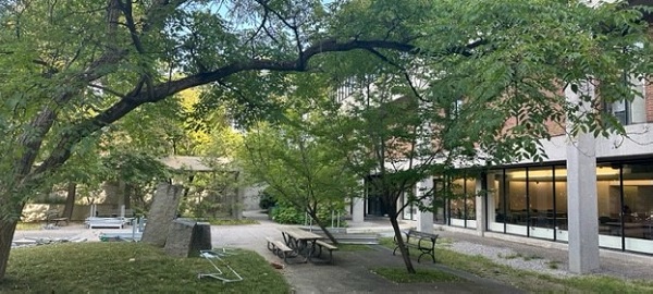 A photo of the outdoor space (the Vanier Quad) showcasing the Quad's trees, greenspace and scenery.
