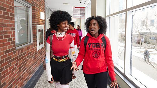 two female students walking in Seneca building 