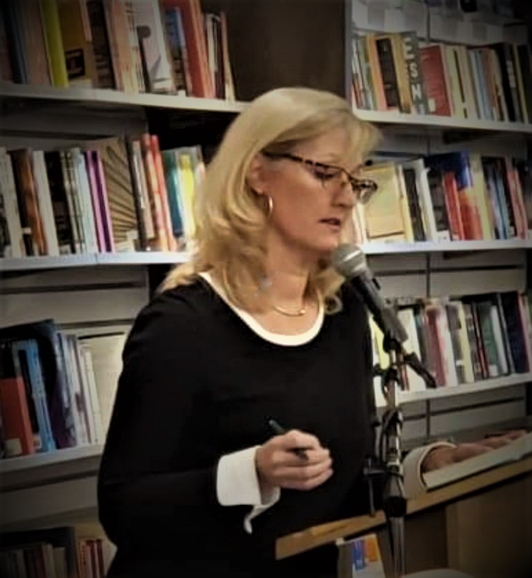 A photograph of Professor Elicia Clements speaking at a podium.
