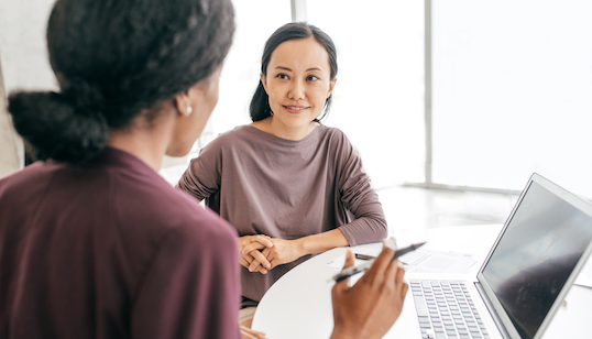 two women in conversation at desk