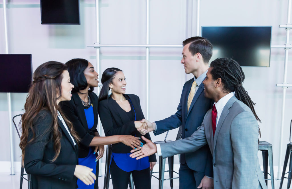 five young professionals shaking hands