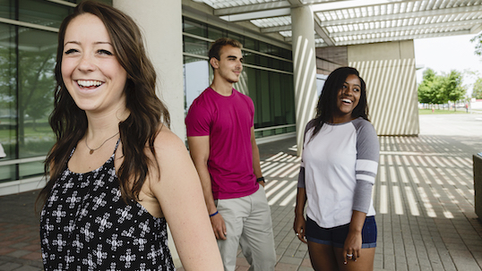 Three York students smiling while standing outside of TEL building on Keele Campus