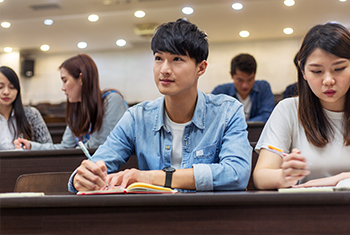 focused image of two Asian students sitting in a lecture