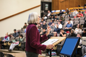 side shot of a professor at the podium during a lecture