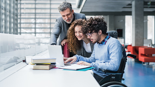 three people using a laptop