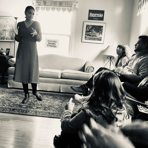 Young woman speaking to small group of people by Celia Ringstrom