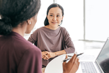 two women in conversation at desk