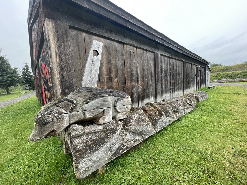 carved wooden poles and old building