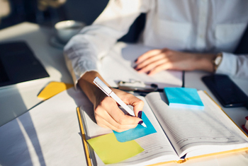 close up of person writing in notebook