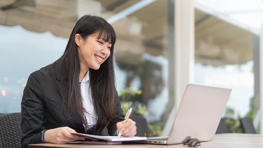 young east asian professional woman using laptop