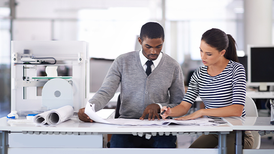 two professionals studying documents on desk