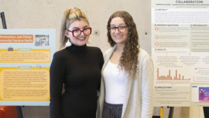 two students stand in front of their dare projects during the 2022 reception