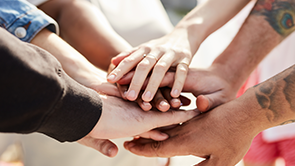 Hands of a diverse group of people stacked on one another