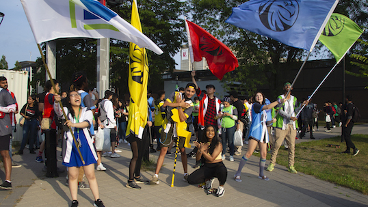 New College students participate in orientation day by waving the college's flags outside. 