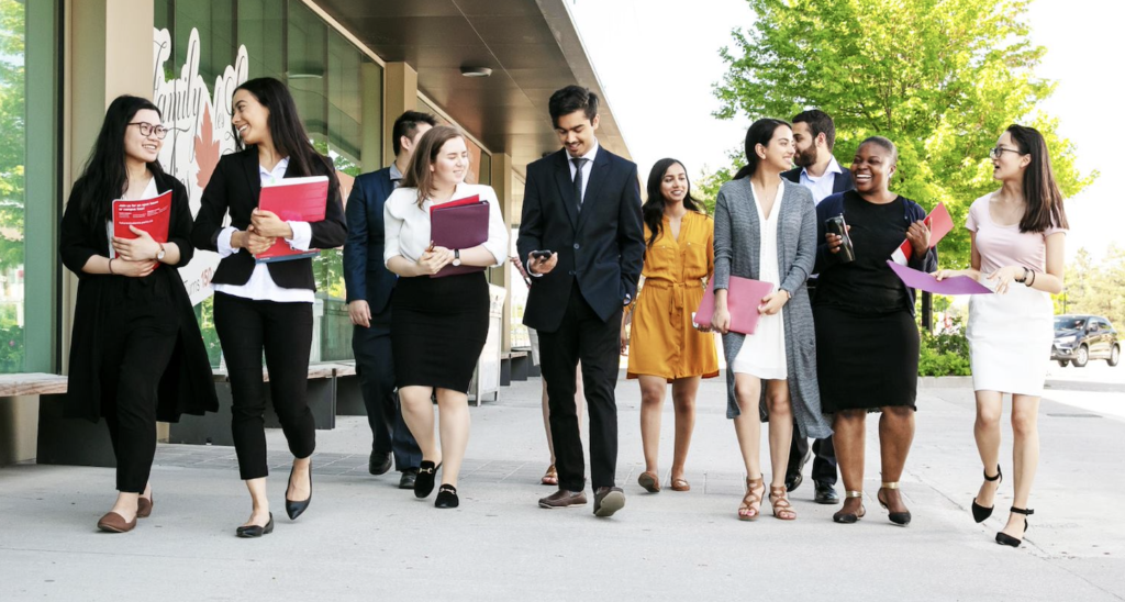 A group of students walking together, talking and smiling