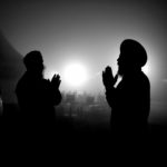 Two farmers in the dark with hands together (praying).