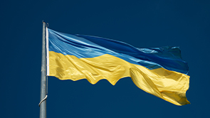 Ukrainian national flag hanging at full mast against a blue sky