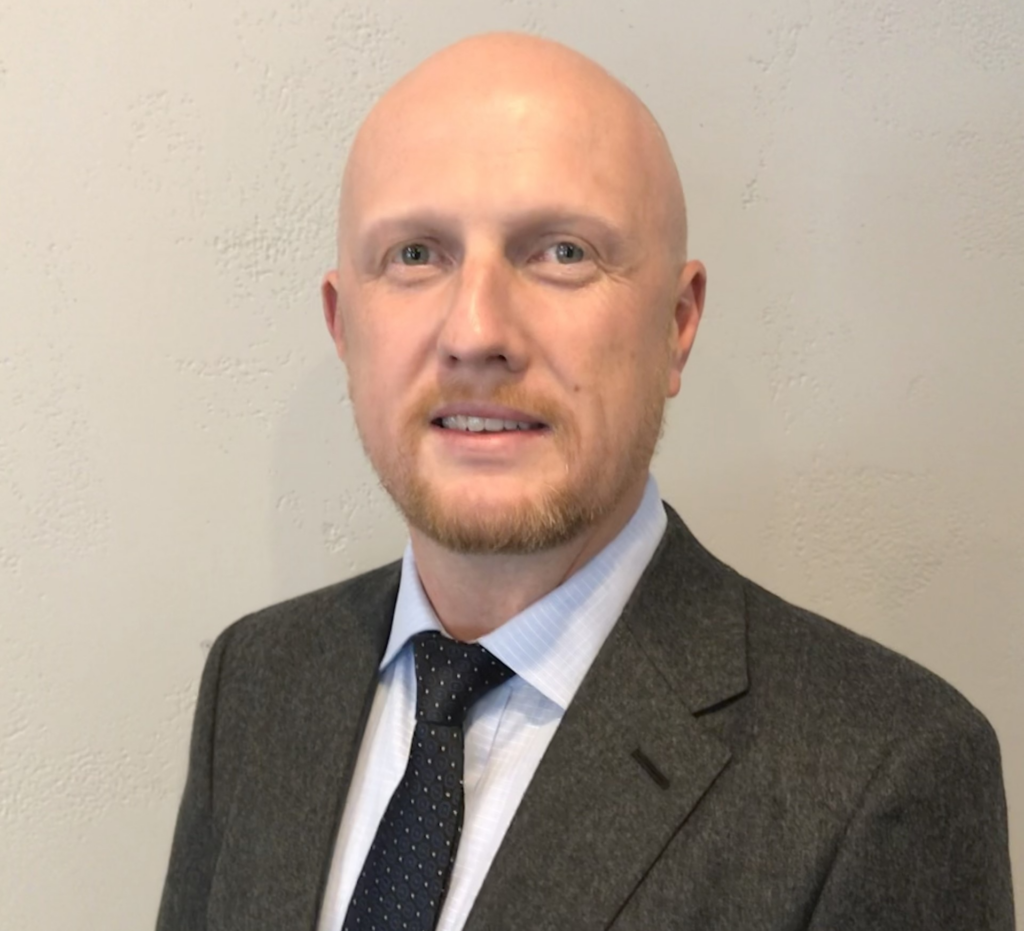 Headshot of Professor Ian Stedman wearing a suit and tie