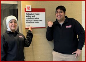 Two students standing outside the SPPA main office at YorkU