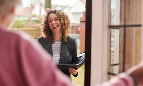 social worker greeting person in doorway