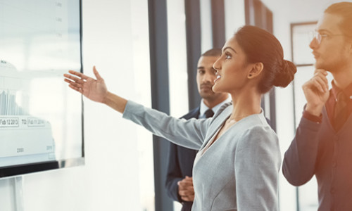 professional woman gesturing at whiteboard