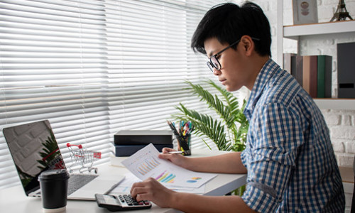 young asian male accountant focused on his work at a desk