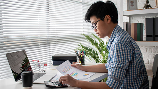 young asian male accountant focused on his work at a desk