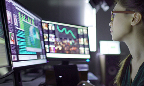 Criminology young female researcher studying crime trends on her computer screens