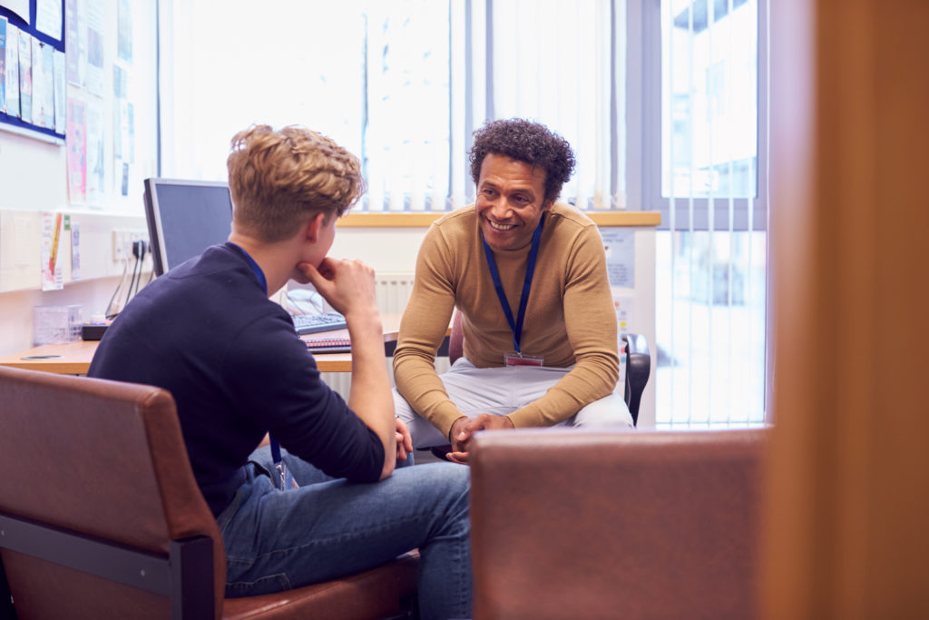 An advisor speaking with a student speaking in an office