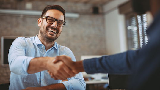 Two men shaking hands and smiling